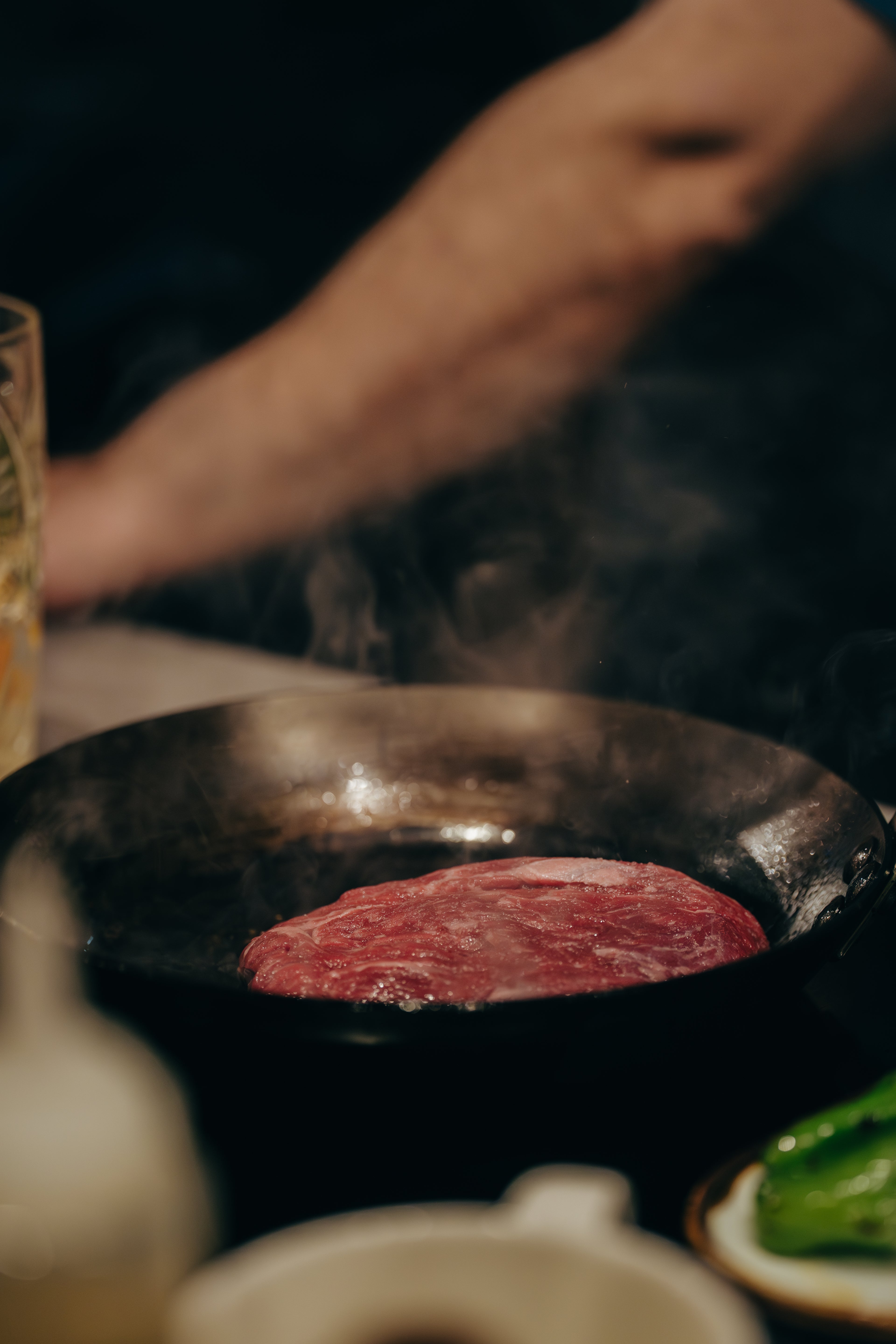 Wagyu Steak wird in einer gusseisernen Pfanne angebraten, aromatischer Dampf steigt auf – The Meat Boutique Premiumfleisch.